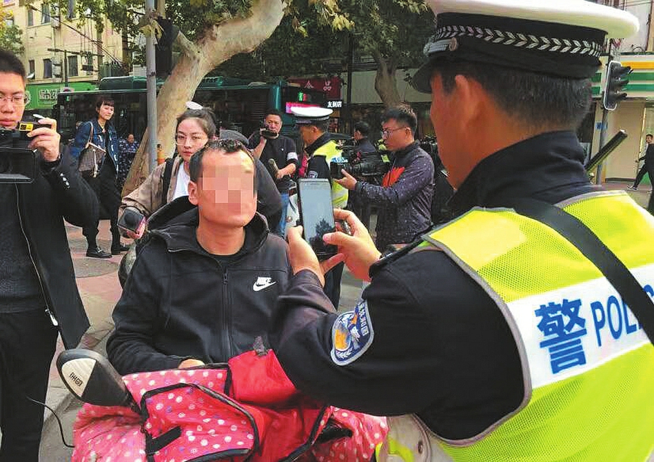 不吓唬你,骑车使用手机违法 交警首次上路查处“骑车”玩手机